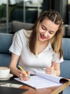 young-lady-writing-her-notes-gesture-thumb-up-restaurant_114579-92524